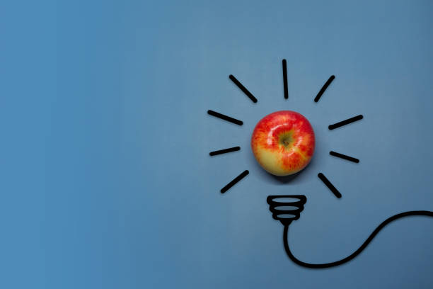 istock Creative thinking ideas and innovation concept. A ball of apple with a light bulb symbol on a blue background. Time for a healthy diet 1459557603