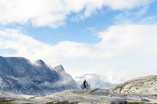 istock Man riding bicycle in the mountains under a blue sky 1459558805