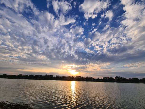 istock Scenic view of the sunset over a lake under blue cloudy sky 1459559608