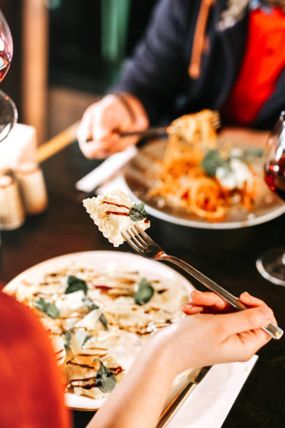 Young woman eating delicious Ravioli with cream and cheese at restaurant Young woman eating delicious Ravioli with cream and cheese at restaurant cooked selective focus vertical pasta stock pictures, royalty-free photos & images