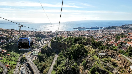 Madeira Funchal, Portugal – January 04, 2022: A panoramic view of a city and ocean from a teleferic cabin in Funchal, Island of Madeira
