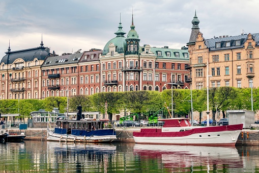 A beautiful view of the boats in the river near the buildings in Stockholm, Sweden