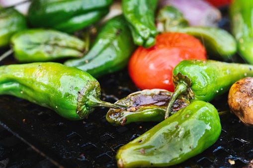 a closeup of roasted green peppers and tomatoes
