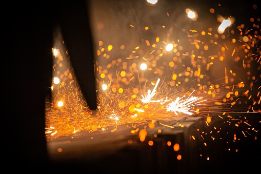 A shallow focus of sparks during a cutting process in a workshop