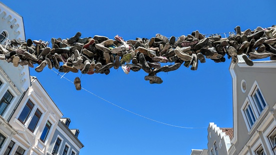 Low angle closeup shot of a pile of shoefiti of sneakers on a street in downtown Flensburg, Germany