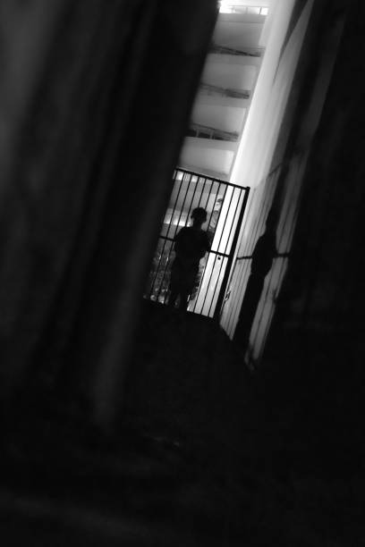 istock Vertical grayscale shot of a spooky silhouette on a staircase 1459564532