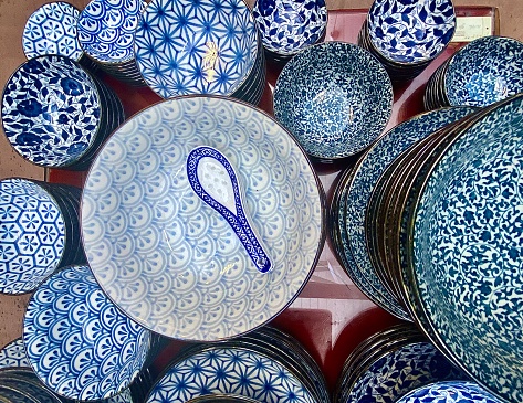 Horizontal flat lay still life of Chinese bichromatic domestic kitchen table ware of bowls in various blue and white design patterns in Byron Bay store Australia