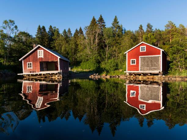 istock Beautiful view of barns by a reflective lake with trees 1459565648