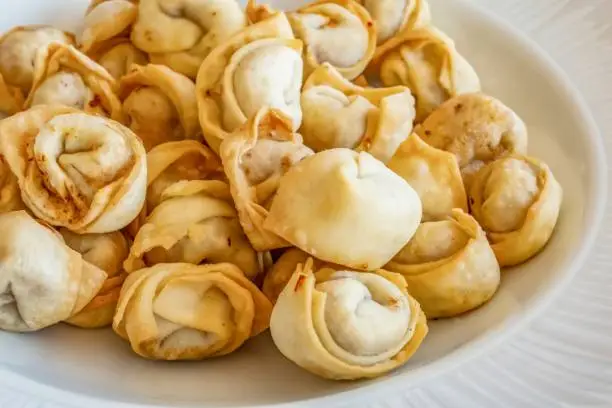 Photo of Bowl of Manti in a plate on the table