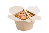 Wok with meat in a paper box on a white background.