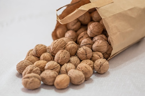 A paper bag of ripe and shelled walnuts
