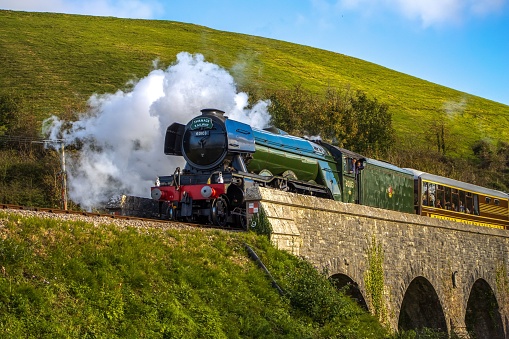 Swanage, United Kingdom – October 24, 2022: The old-fashioned Flying Scotsman train steaming on the Corfe Viaduct