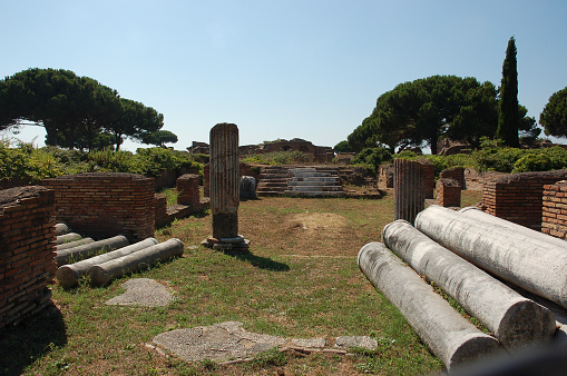 The ruins in Ostia Antica archaeological site in Rome Italy in daylight with trees in the background