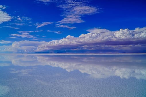 A scenic daytime shot of the Uyuni Salt Flat with a cloudscape in the background