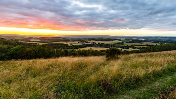 Scenery of celestial body in the cloudy sky at dramatic sunrise over South Harting, UK