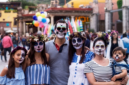 San Miguel de Allende y Ciudad de Mexico, Mexico – November 02, 2018: A beautiful shot of a family wearing skull makeup celebrating the day of dead