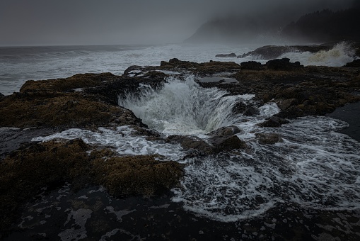 The view of Thor's Well on a cloudy day. Oregon, Cape Perpetua Scenic Area, USA.