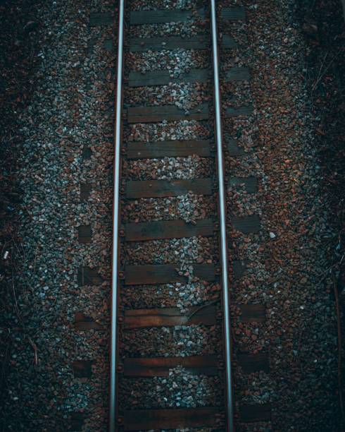 istock Vertical shot of an old rusty railroad surrounded by grey pebbles - great for dark backgrounds 1459574045
