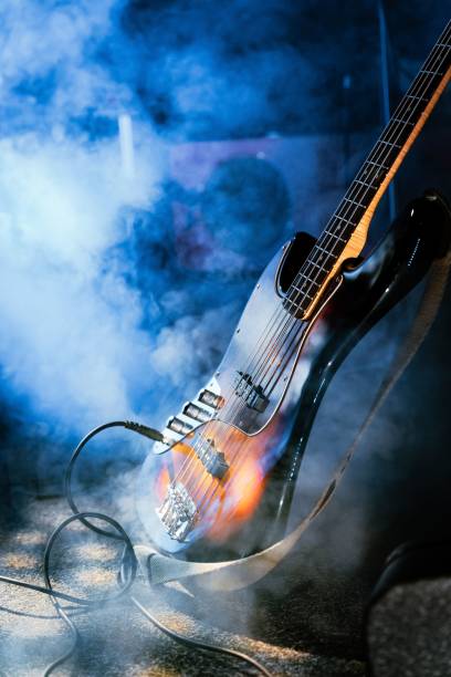 Vertical shot of a bass guitar on the stage with a fog machine A vertical shot of a bass guitar on the stage with a fog machine bass instrument stock pictures, royalty-free photos & images