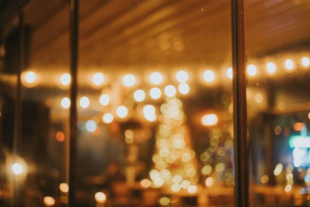 The bokeh lights of a bright Christmas tree in a beautifully decorated empty cafe