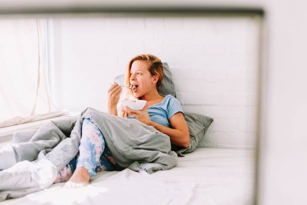 istock Young woman has breakfast in bed 1459575371