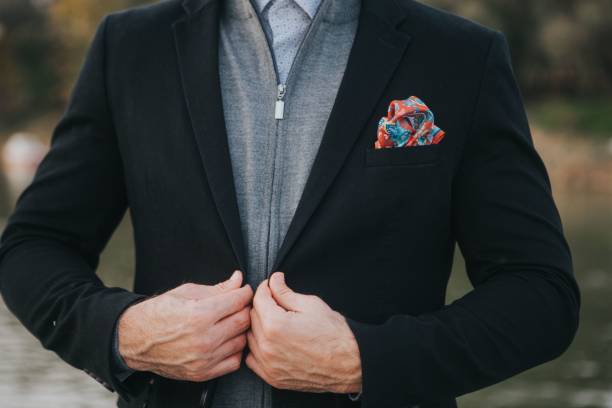 istock Man fixing his black coat suit over a casual gray zipper jacket 1459576492