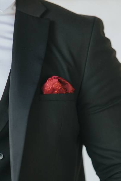 istock Vertical shot of a man's black suit jacket with a maroon pocket square 1459576509