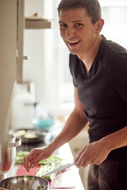 istock Vertical shot of a white German man cooking 1459578161