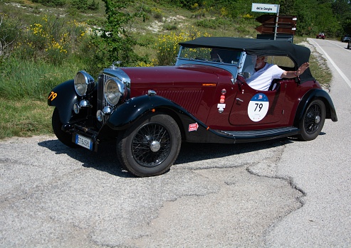 urbino, Italy – June 16, 2022: URBINO - ITALY - JUN 16 - 2022 : BENTLEY 3,5 LITRE 1934 on an old racing car in rally Mille Miglia 2022 the famous italian historical race