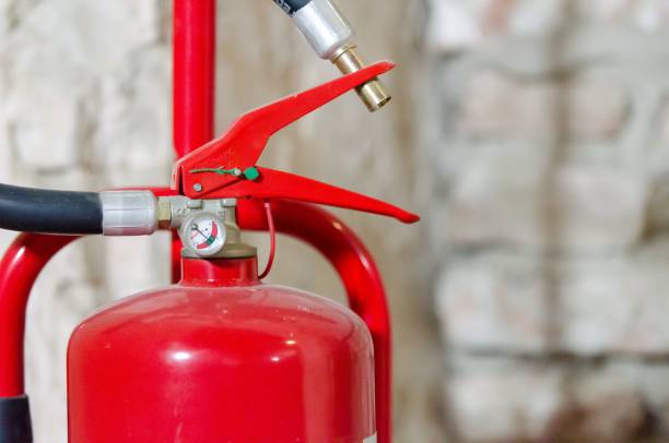 istock Closeup of a red fire extinguisher on a blurry background 1459578684