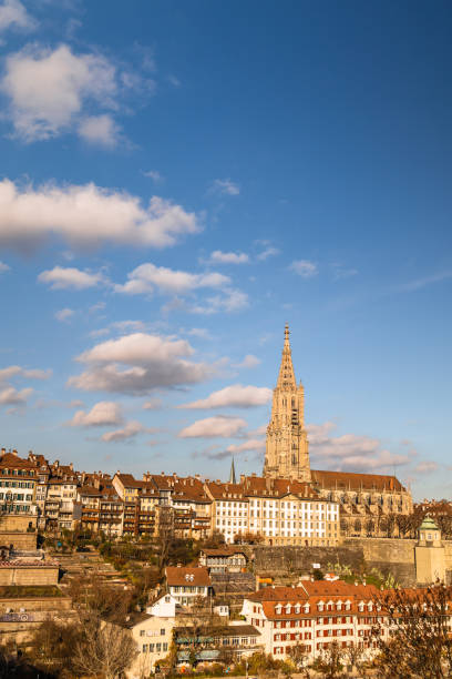toma vertical del paisaje urbano con la catedral de berna en un día soleado, suiza - berne berne canton roof cityscape fotografías e imágenes de stock