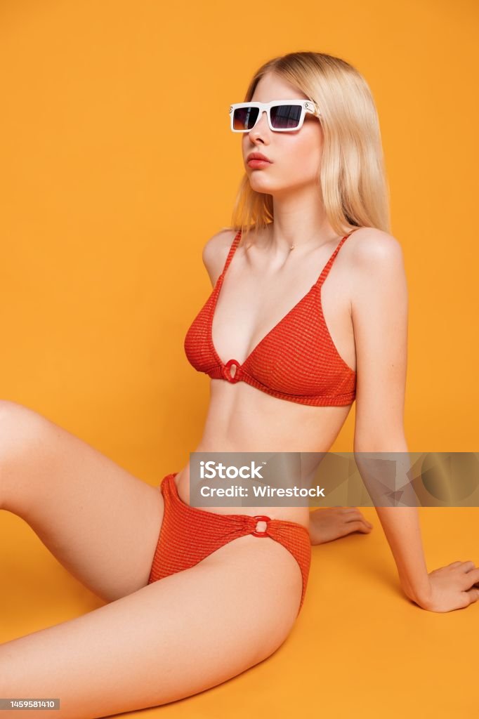 수영복과 선글라스를 쓴 젊은 금발 러시아 소녀가 노란색 배경에 포즈를 취하고 있다 관능에 대한 스톡 사진 및 기타 이미지 - 관능,  금발 머리, 나이 - Istock