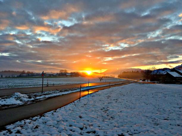 istock Beautiful cloudy sunset sky over the road covered in snow. 1459584438