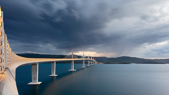 Panoramic image of beautiful modern multi-span cable-stayed Peljesac Bridge over the sea in Dubrovnik-Neretva County, Croatia at sunset.