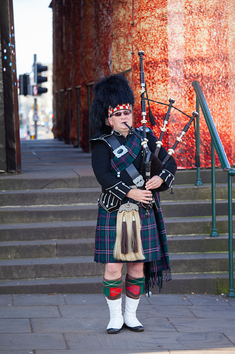 Edinburgh,Scotland October 16, 2015 A Scotsman wearing traditional Scottish outfit playing the bagpipes along the Royal Mile in Edinburgh