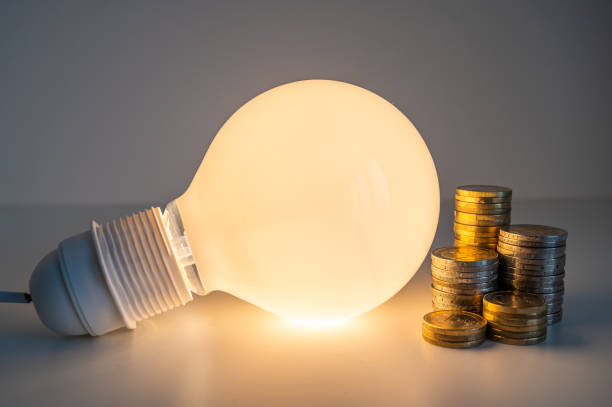 istock Light bulb and coins next to it. Energy costs. 1459587246