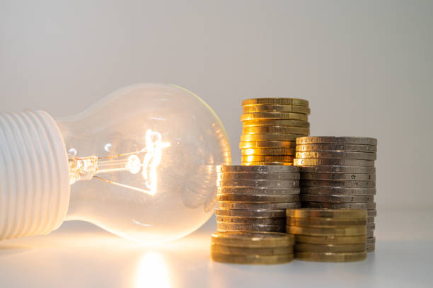 istock Light bulb and coins next to it. Energy costs. 1459587454