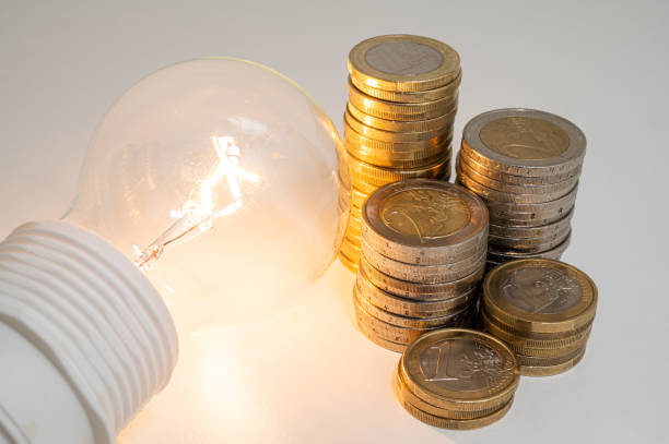 istock Light bulb and coins next to it. Energy costs. 1459587589