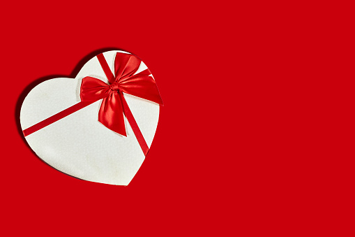 white heart shaped box for valentine's day or christmas on red background