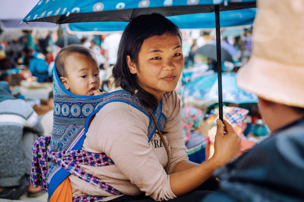 mulher vietnamita que carrega um bebê nas costas no mercado das terras altas - bac ha - fotografias e filmes do acervo
