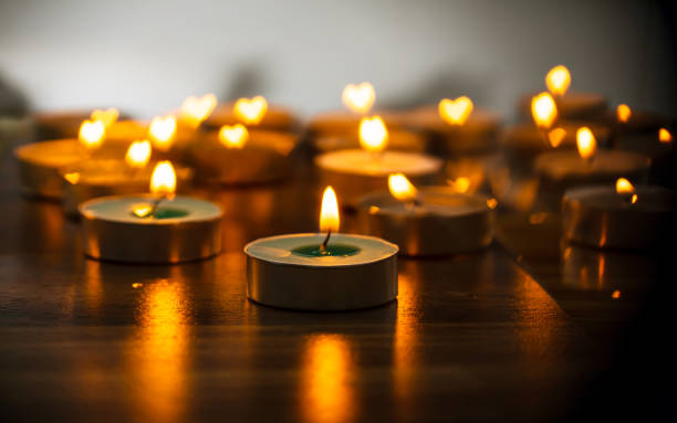 istock Yellow candle light lit on wooden table. 1459593017