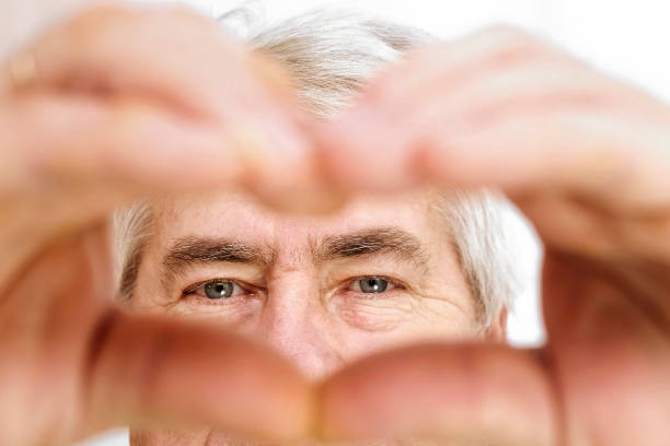 istock Happy Old Senior Man Making Heart Shape Hand Gesture. Look at Camera, Showing Romantic. Retired Elderly Grandparent Close Up Portrait. Symbol of Love Yourself. Doing charity Work, take Care of Health. 1459593651
