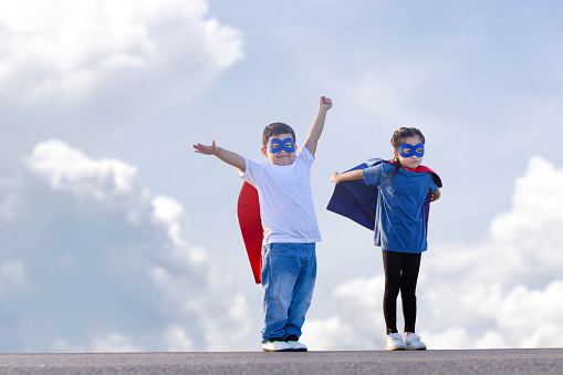 Superheroes kids friends having fun outdoor, boy and girl with clipping path playing outdoors, Brother and sister playing outdoors