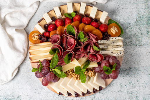 Cold Smoked Meat Plate, antipasto set platter wooden plate. Antipasto board with sliced meat, ham, salami, cheese. Top view with close up