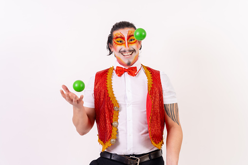 Clown opening a birthday present and confetti flying around isolated on white background