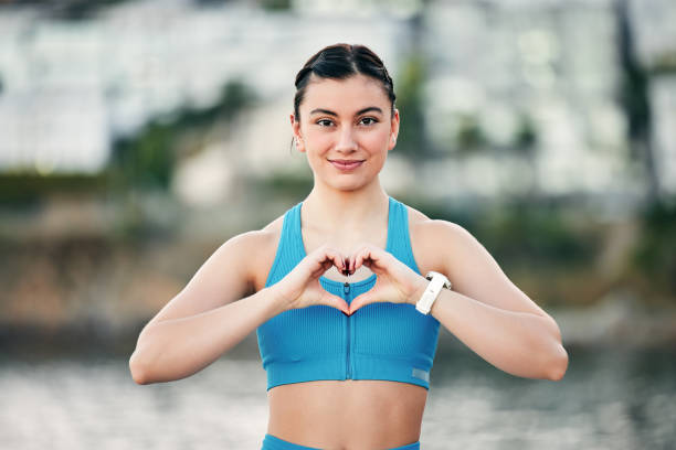 Exercise, portrait and woman with heart hand for wellness, health and happiness on run rest. Runner, fitness and youth with love sign on workout break for self love, care and smile in nature. ejercicio, retrato y mujer con corazón mano para el bienestar, la salud y la felicidad en el descanso de la carrera. corredor, fitness y juventud con signo de amor en el descanso de entrenamiento para el amor propio, el cuidado y la sonrisa en la naturale