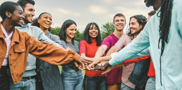 joyful team of multi-ethnic young people joining hands together - people diversity culture concept joyful team of multi-ethnic young people friends joining hands together - diversity, unity, trust, oneness, international youth culture concept - interracial person connecting together multi ethnic group college student group of people global communications stock pictures, royalty-free photos & images