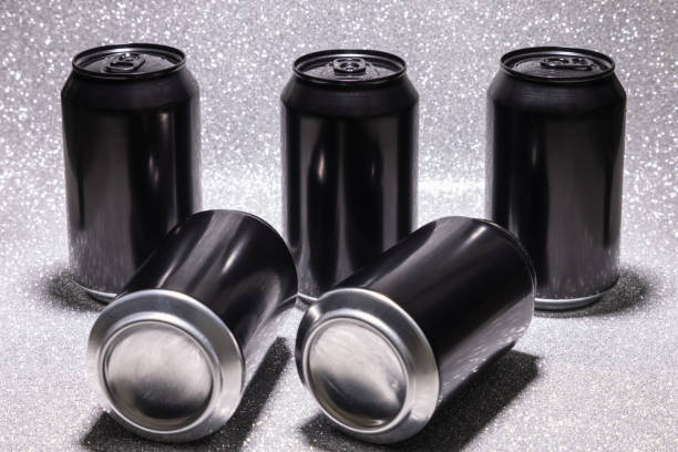 istock Black blank aluminum cans on a white background with glitter under hard light (focus on the cans in the background) 1459601030