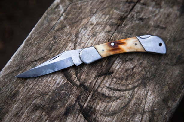 istock Folding knife on a wooden board 1459601173