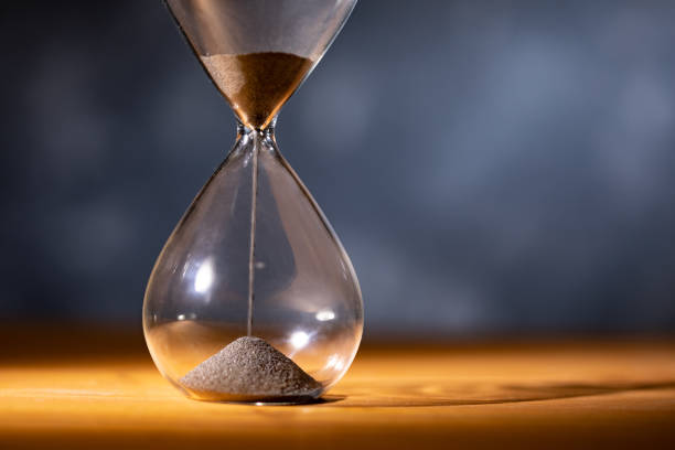 istock Hourglass on a wooden table 1459602350